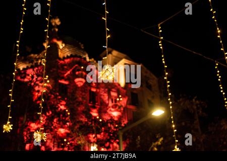 Barcelona's enchanting holiday nights: Casa Batlló bathed in festive red, framed by the sparkling dance of city lights, creating a magical urban Chris Stock Photo