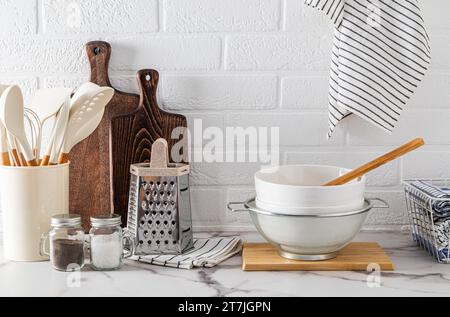 A set of various kitchen tools made of eco-friendly materials on a marble white countertop. Front view. A cozy, zero-waste home Stock Photo