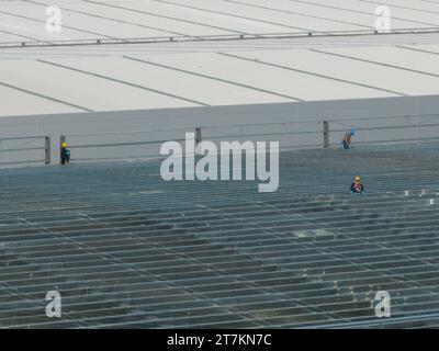 HEFEI, CHINA - NOVEMBER 16, 2023 - Workers build a steel structure plant at the construction site of GCL PV's second phase plant project in Hefei, Anh Stock Photo