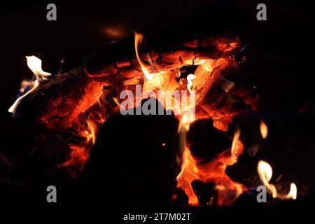 A summer fire is burning down late into the night, bringing warmth as in the darkness. The contrast between the heat and dark strengthens the flames. Stock Photo
