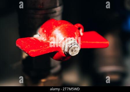 Closed red valve on plastic and metal pipe with hot water. Hot water is turned off Stock Photo