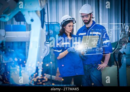 Engineers team mechanic using computer controller Robotic arm for welding steel in steel factory workshop. Industry robot programming software for aut Stock Photo