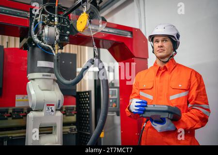 Engineers mechanic using computer controller Robotic arm for welding steel in steel factory workshop. Industry robot programming software for automate Stock Photo