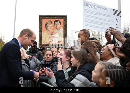 The Prince of Wales meets with well-wishers as a member of the public holds a painting depicting Diana, Princess of Wales, King Charles III and Prince William during his visit to the Moss Side Millennium Powerhouse, a community hub with a mission to create brighter futures for young people in Manchester, and to hear about the work of Keeping It Real 24/7, a foodbank and community lifeline. Picture date: Thursday November 16, 2023. Stock Photo