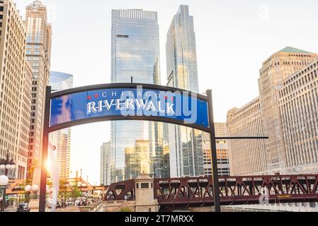 Chicago riverwalk sign with skyscrapers in background at sunset Stock Photo