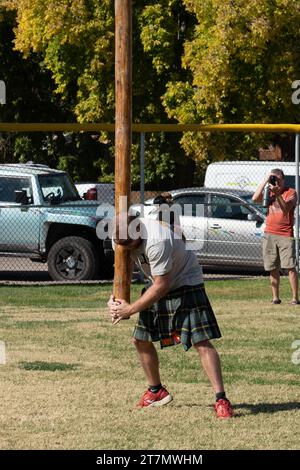 A competitor in a kilt tosses the caber in the Highland games at the Moab Celtic Festival, Scots on the Rocks, in Moab, Utah. Stock Photo