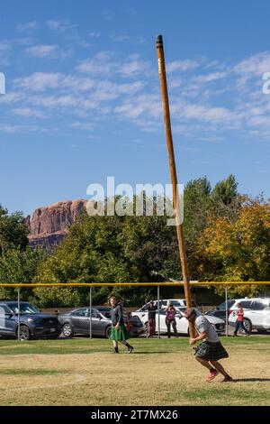 A competitor in a kilt tosses the caber in the Highland games at the Moab Celtic Festival, Scots on the Rocks, in Moab, Utah. Stock Photo