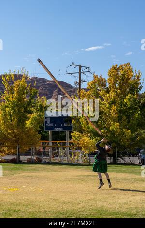 A competitor in a kilt tosses the caber in the Highland games at the Moab Celtic Festival, Scots on the Rocks, in Moab, Utah. Stock Photo