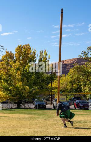 A competitor in a kilt tosses the caber in the Highland games at the Moab Celtic Festival, Scots on the Rocks, in Moab, Utah. Stock Photo