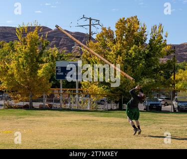 A competitor in a kilt tosses the caber in the Highland games at the Moab Celtic Festival, Scots on the Rocks, in Moab, Utah. Stock Photo