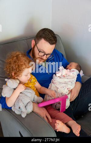 Father playing with his daughters on a tablet Stock Photo