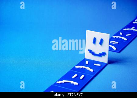 Concept of a happy face around sad and angry faces. Stock Photo