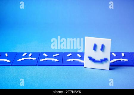 Concept of a happy face around sad and angry faces. Stock Photo