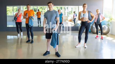 Group of people with gym equipment smiling and standing in a fitness center. Teamwork Concept image Stock Photo