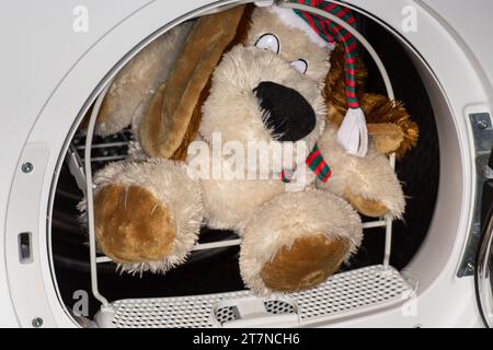 children's soft toy in the dryer basket after washing, home life. Stock Photo