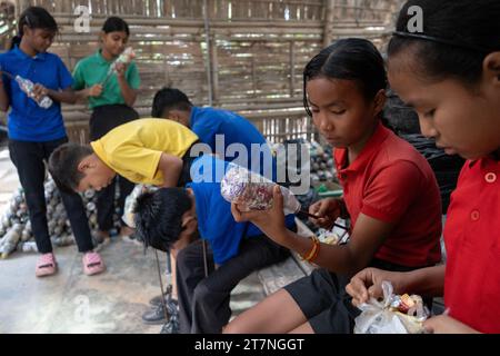 November 16, 2023: Students put plastic bags inside plastic bottles to make eco-bricks which will be used for construction purposes at the Akshar Forum school in Pamohi in the outskirt of Guwahati in Assam, India on 16 November 2023. Akshar Forum is a free 100 student model school established in 2016 in Assam, they accept plastic waste as school 'fees' from students. (Credit Image: © David Talukdar/ZUMA Press Wire) EDITORIAL USAGE ONLY! Not for Commercial USAGE! Stock Photo