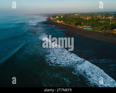 Aerial view of black sand beach with ocean waves in Keramas, Bali Stock Photo