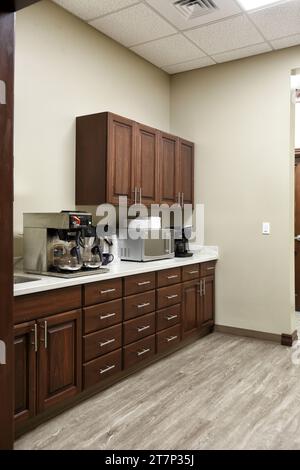 A modern break room in a small office building, with coffee maker, cabinets, and microwave. Stock Photo