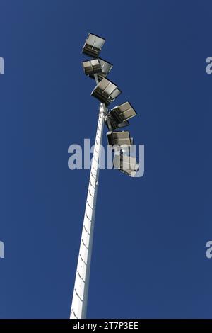 New, modern, energy saving, stadium lights, isolated against a blue sky, and mounted high on top of poles to illuminate a high school football stadium. Stock Photo
