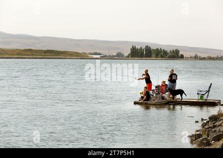 A family fishes from a floating dock on Gem Lake in Idaho Falls, Idaho. Stock Photo