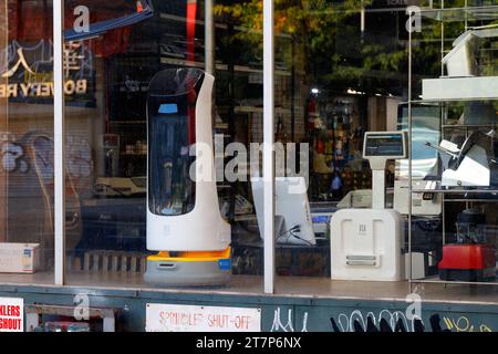 A Pudu Robotics Kettybot automated smart delivery robot, retail service robot, in the window of a Bowery restaurant supply store in New York City. Stock Photo