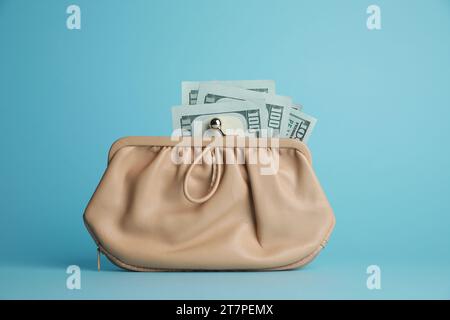 One stylish leather purse with money on light blue background Stock Photo
