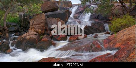 Landscape image of blurred water cascade over red rocks at National Park Falls, John Forrest National Park, Perth, Western Australia, Australia Stock Photo