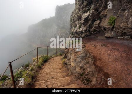 Hikers on the PR1 Vereda do Areeiro hiking trail in the fog, from Pico do Arieiro to Pico Ruivo, Madeira, Portugal Stock Photo