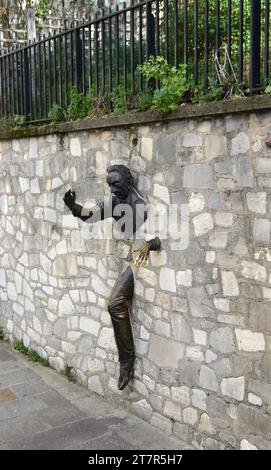 Le Passe-Muraille is a Unusual sculpture of a man embedded in a wall, based on a story by French writer, Marcel Aymé. Montmartre, Paris, France. Stock Photo