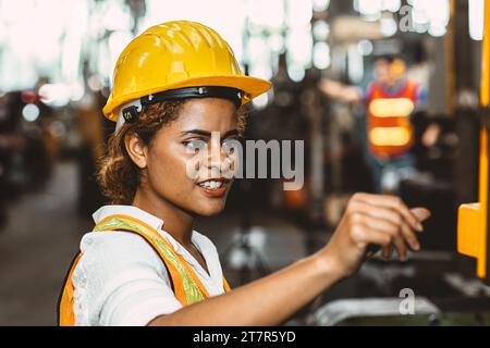 Engineer milling technician African woman worker manual hand skill working in heavy industry control metal lathe machine Stock Photo