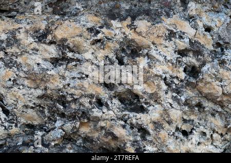 A high resolution image of a grey, stone-like surface featuring small scratches and dark and light speckles Stock Photo