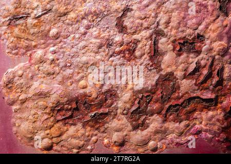 A closeup of a rusty painted surface on a red car Stock Photo