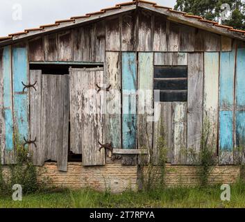 A scenic view of an old rustic house surrounded by red rocks in a small ...