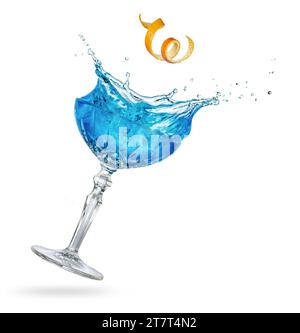 Orange spiral peel falling into a splashing blue cocktail tilted on white background. Real studio photo shot. Stock Photo