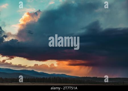 Storm clouds over the mountains with sunset Stock Photo