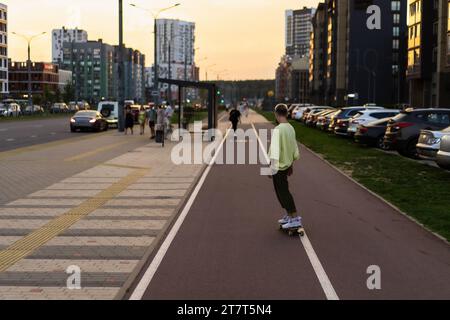 A young woman rides a skateboard along the city streets. Stock Photo