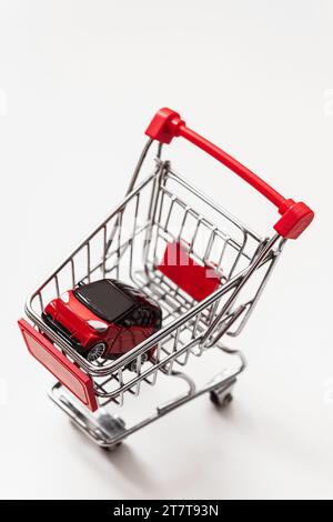 Red toy car inside small shopping cart Stock Photo