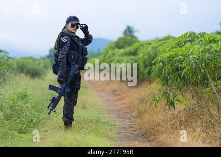 A young female wearing a black jacket and holding an airsoft rifle Stock Photo