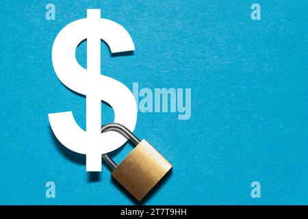 Padlock attached to a white dollar sign on the blue background. Stock Photo