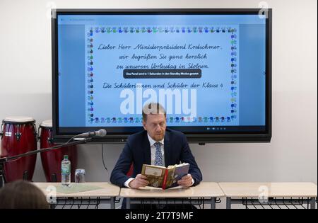 Stolpen, Germany. 17th Nov, 2023. Michael Kretschmer (CDU), Minister President of Saxony, reads from the book 'Mein Freund Otto, das wilde Leben und ich' by Silke Lambeck to primary school pupils in year 4 as part of the nationwide Read Aloud Day at Basaltus Primary School while the screen is set to standby mode in the background. The nationwide Read Aloud Day was launched in 2004 by the weekly newspaper 'Die Zeit', the Reading Foundation and Deutsche Bahn. Credit: Robert Michael/dpa/Alamy Live News Stock Photo