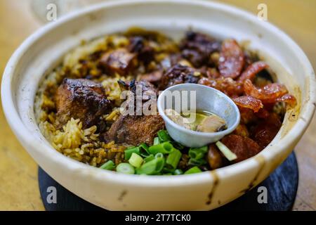 Heung Kee claypot chicken rice with glutinous rice, lap cheong (Chinese sausage), salted fish, spring onion cooked on a traditional charcoal stove Stock Photo