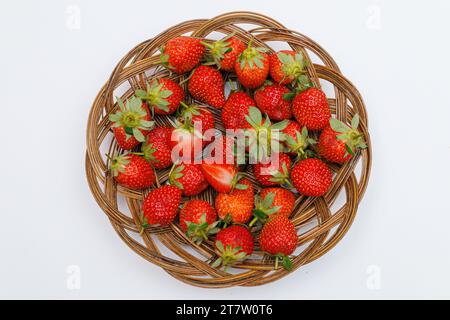 Ripe strawberries in a wicker tray top view on a white background. Stock Photo