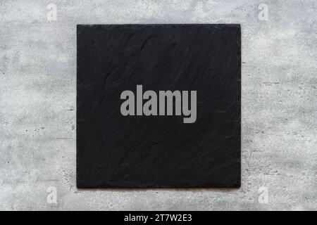 Black slate board on gray textured stone background, top view Stock Photo