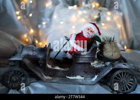 Santa Clause driving a vintage motor car and delivering presents in the snow Stock Photo