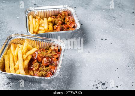 Traditional German currywurst with french fry served take away. Gray background. Top view. Copy space. Stock Photo