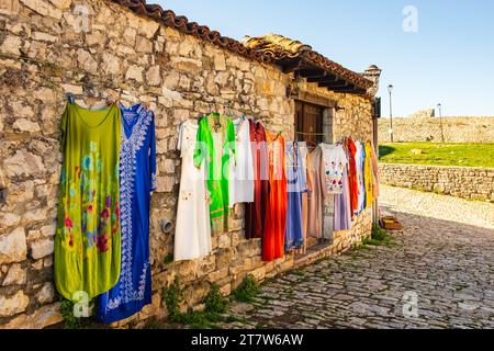 Outdoor street market with traditional Albanian clothing. Hanging beautiful traditional dresses different colors and decoration at market, bazaar, fas Stock Photo