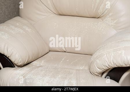 Defects on a white leather sofa. Damaged to leather furniture. Stock Photo