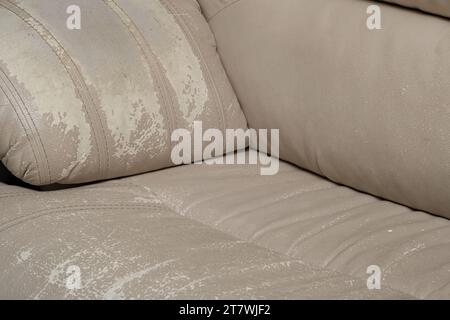 Defects on a white leather sofa. Damaged to leather furniture. Stock Photo