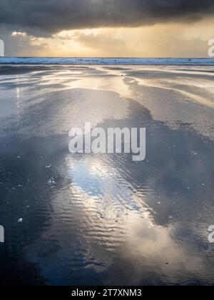 Rain clouds and reflections on Rhossili beach at sunset showing the shipwreck of the Helvetia, Rhossili, Gower, South Wales, United Kingdom, Europe Stock Photo