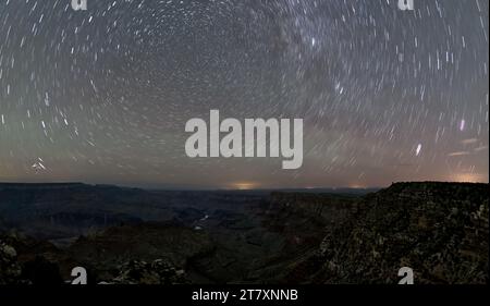 The swirl of stars in the night sky over Grand Canyon South Rim viewed from Navajo Point with the historic Watchtower Stock Photo